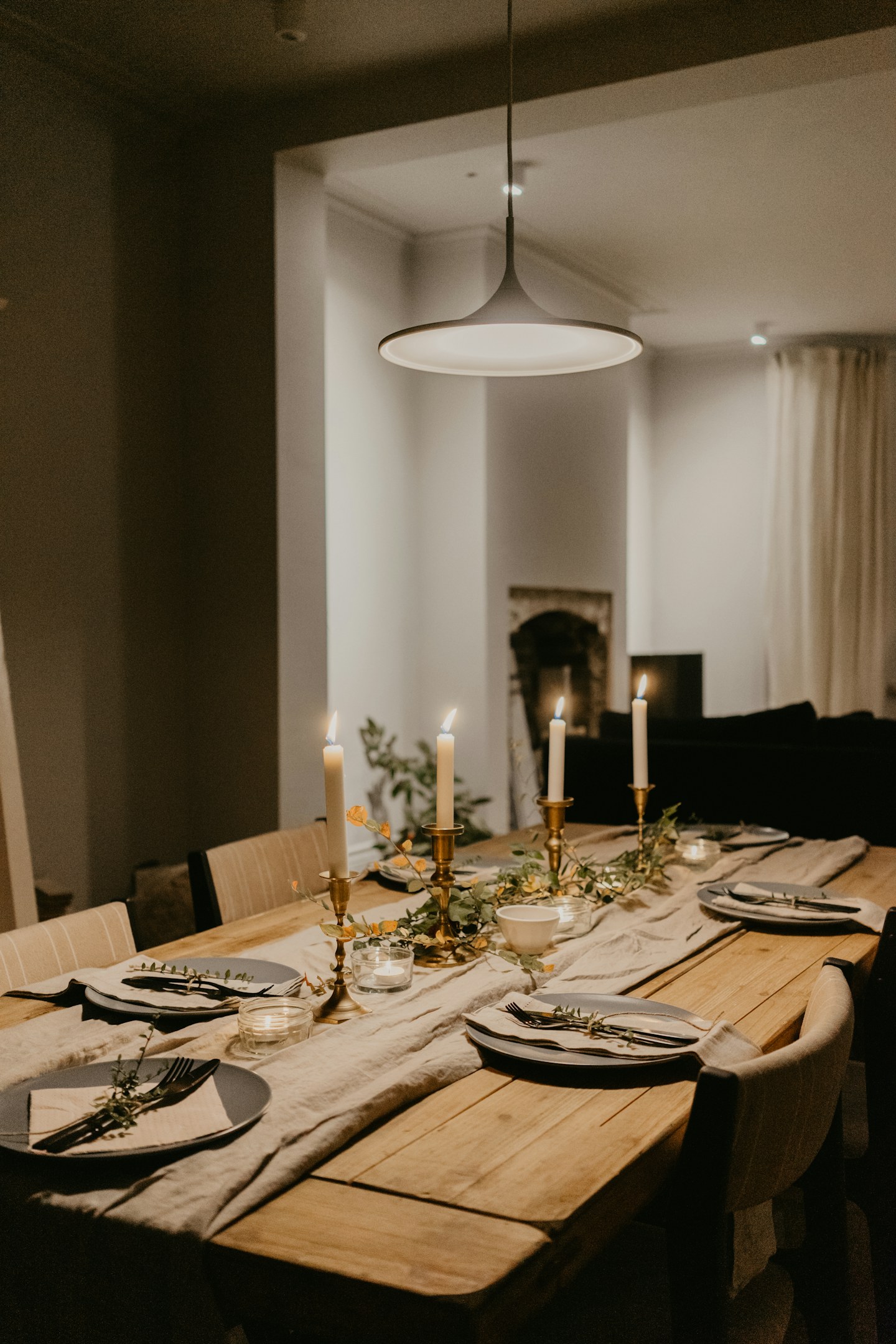 A dining table arranged with plates, glasses, and flowers.
