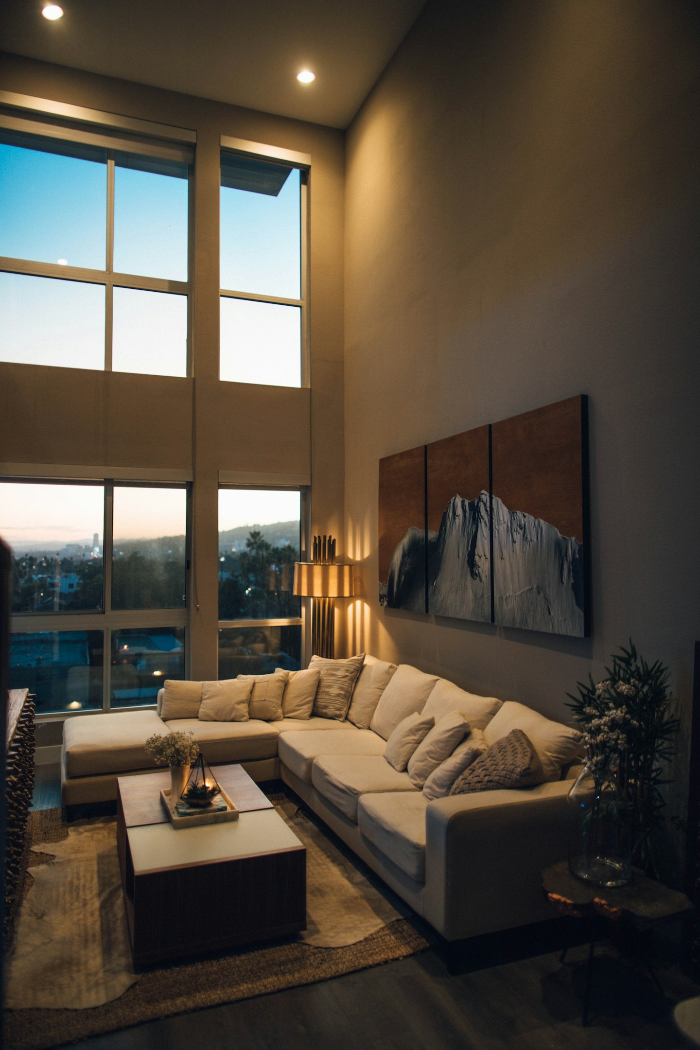 A softly lit living room with a sofa, coffee table, and patterned rug.